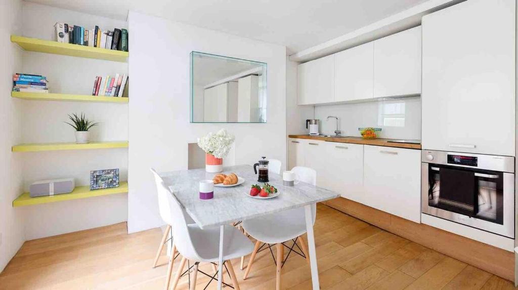 eine Küche mit einem Tisch und Stühlen im Zimmer in der Unterkunft Fitzrovia Apartment By Morethanstays in London