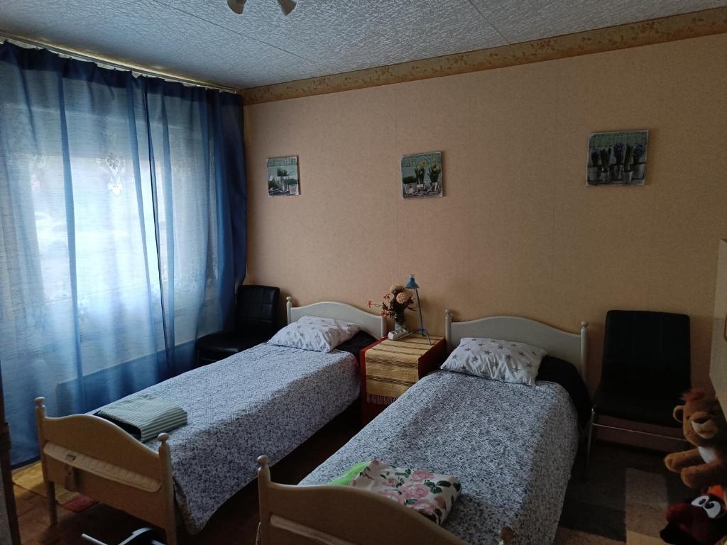 a bedroom with two beds and a teddy bear sitting on a table at Ristiina Apartment with Sauna in Ristiina