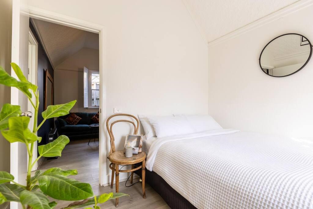 ‘Attunga’-1 min to Sovereign Hill, CBD, wifi, bath في بالارات: غرفة نوم بيضاء مع سرير ومرآة