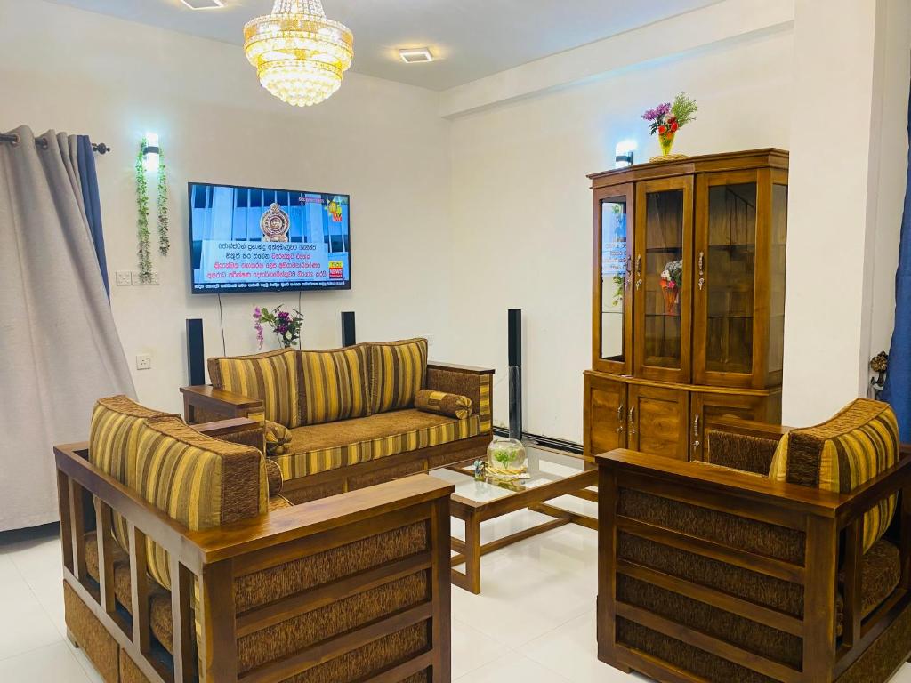 sala de estar con 2 sofás y TV en SAKURA Guest House Tourist only, en Wariyapola