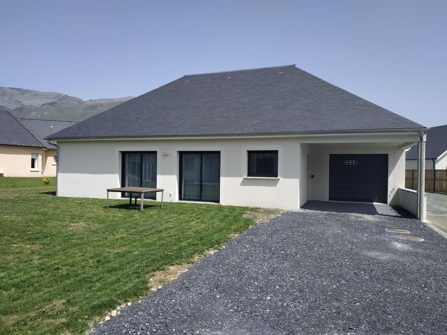 una casa bianca con una panchina nel vialetto di Maison climatisée accessible PMR ad Argelès-Gazost