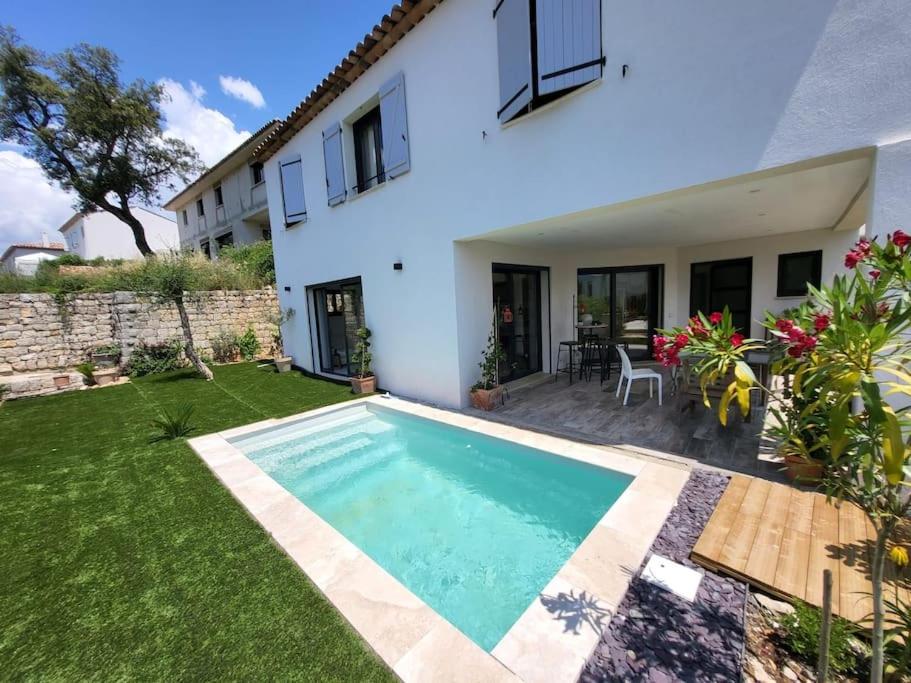 une villa avec une piscine en face d'une maison dans l'établissement Maison avec piscine Côte d'Azur, à Auribeau-sur-Siagne