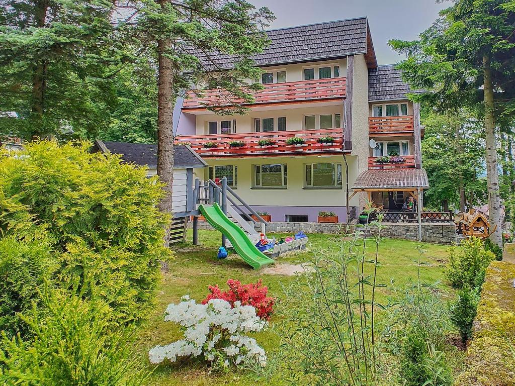 een huis met een groene glijbaan in de tuin bij Willa Świerkowa in Karpacz