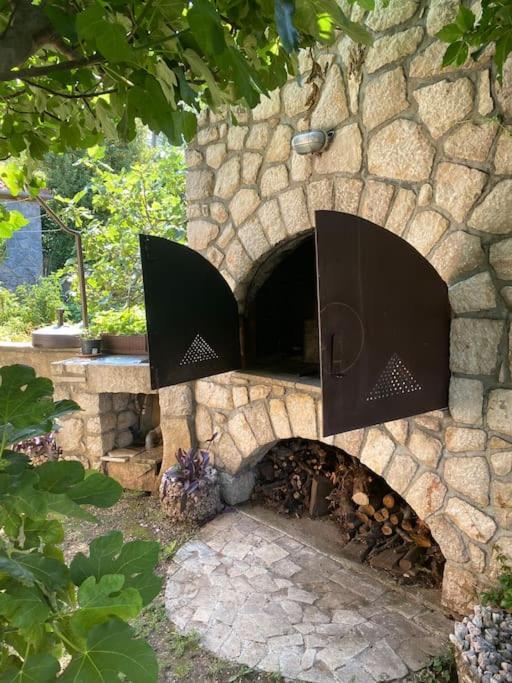 a stone fireplace with a fire place in a yard at Apartment Leda in Kraljevica