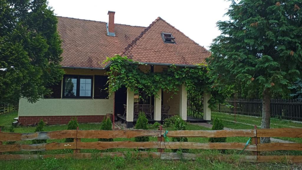 una casa con una valla delante de ella en DOM LETNISKOWY NAD JEZIOREM Łódż wiosłowa i kajak en Wilkasy