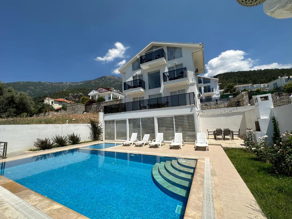 a house with a swimming pool next to a building at Paris A Villa, Özel Havuzlu, Fethiye in Fethiye