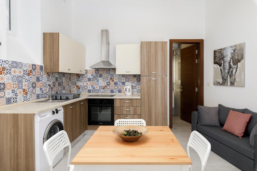 Hamrun的住宿－Modern, Cosy 1BD Apartment - Close to Valletta，厨房以及带桌子和沙发的客厅。