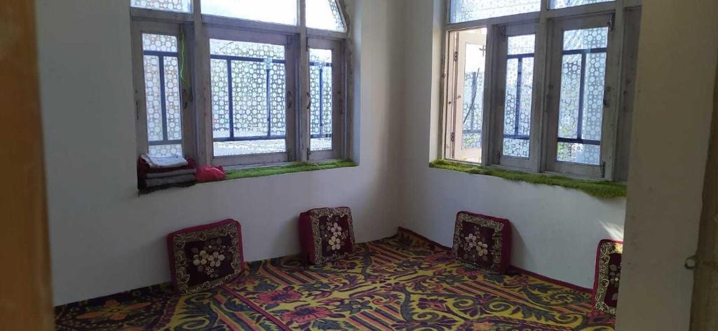 une chambre avec deux chaises et deux fenêtres dans l'établissement POP Masrat Homestay, 