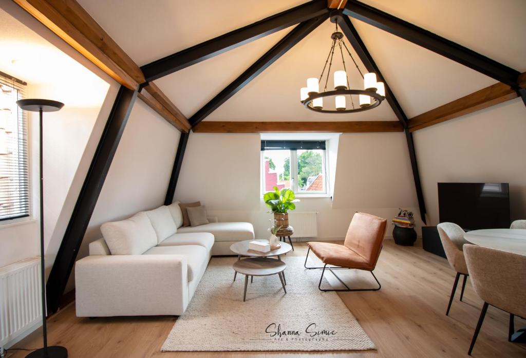 - un salon avec un canapé blanc et une table dans l'établissement ApartHotel De Koning by Urban Home Stay, à Alkmaar