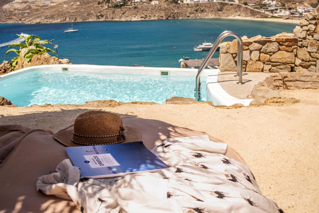 a person laying on a blanket next to a swimming pool at Salty Houses in Kalo Livadi