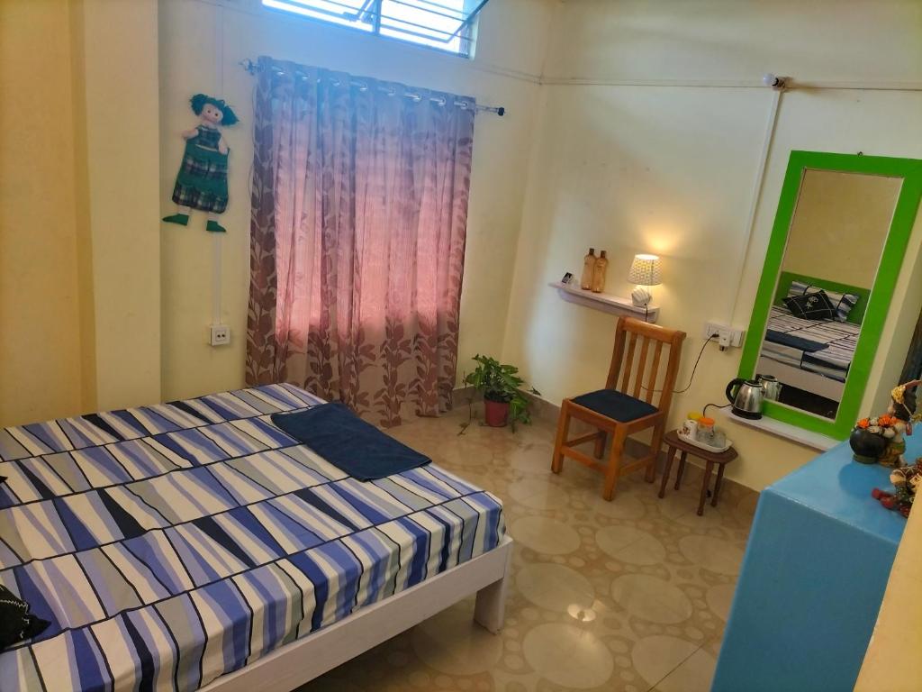 a bedroom with a bed and a mirror and a chair at Cozy Homestay AC 400 per day in Guwahati