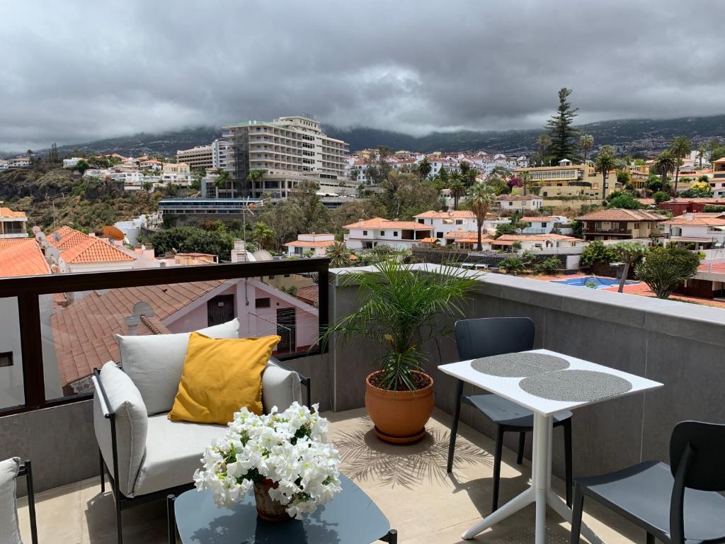 a balcony with a table and chairs and a view of a city at Luxury Atlantic Studio Puerto de la Cruz in Puerto de la Cruz