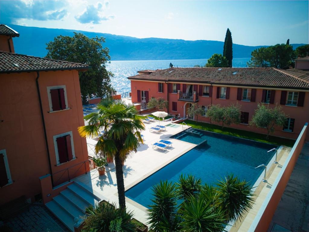 eine Luftansicht einer Villa mit Pool und Gebäuden in der Unterkunft Hotel Bogliaco in Gargnano