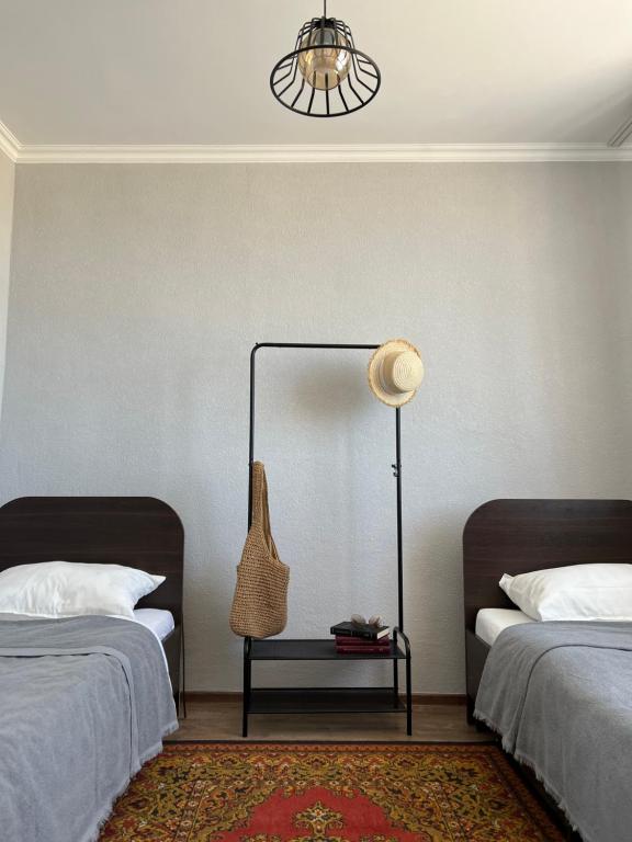 a bedroom with two beds and a lamp on a table at Guest house Hygge in Cholpon-Ata