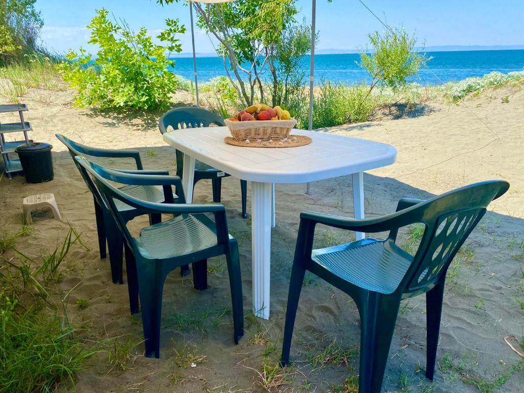 uma mesa com quatro cadeiras e uma taça de fruta em Beachfront Caravans - Meadow Camp em Chernomorets