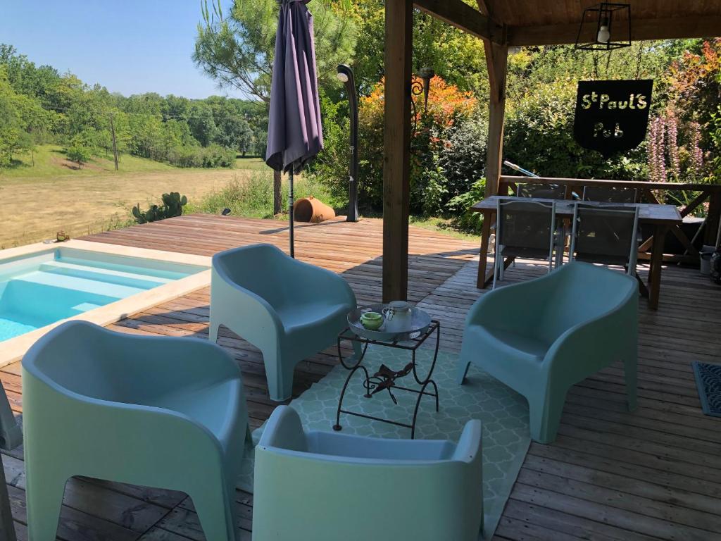 a deck with chairs and a table and a pool at Bellevue in Saint-Paul-Lizonne