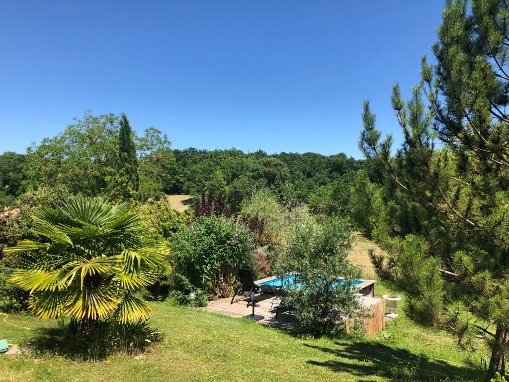 uma vista para um jardim com uma tenda e árvores em BOURGUETTE La petite maison dans la prairie em Saint-Paul-Lizonne