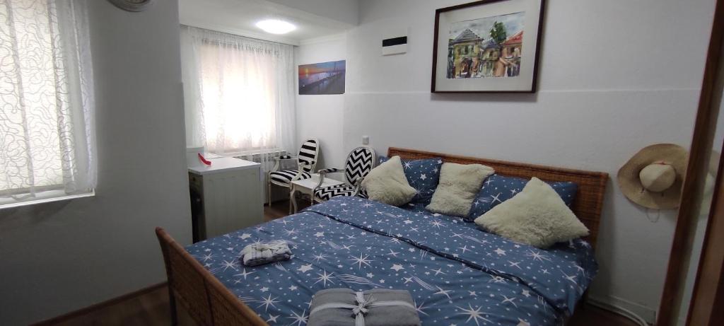 Schlafzimmer mit einem Bett mit blauer Bettwäsche und Kissen in der Unterkunft Apartment 528 in Sarajevo
