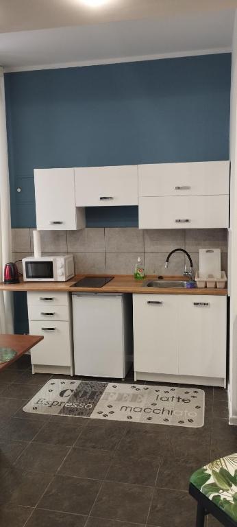 una cucina con mobili bianchi e un lavandino di U Hanki a Łódź
