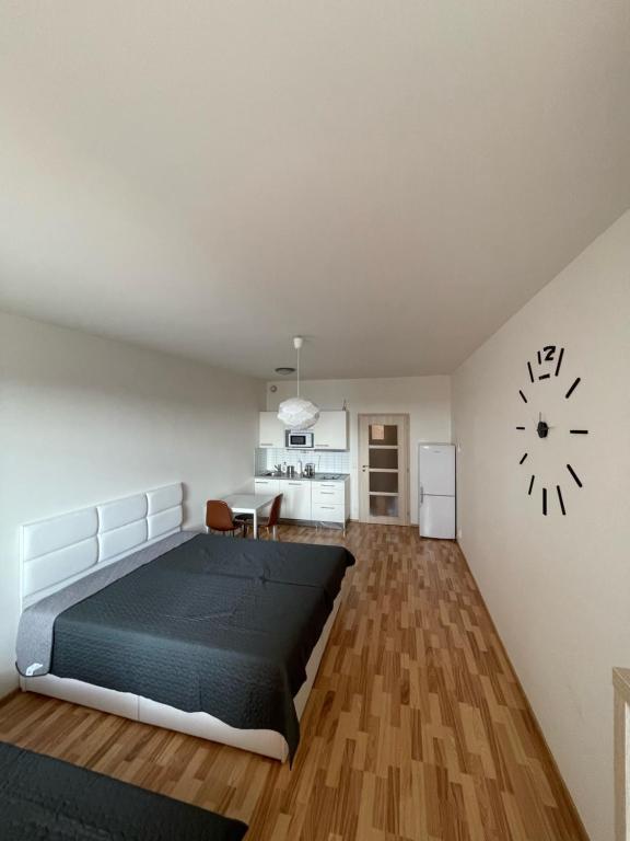 a bedroom with a large bed and a kitchen at Apartment 153 - Rezidence Eliska - Prague 9 in Prague
