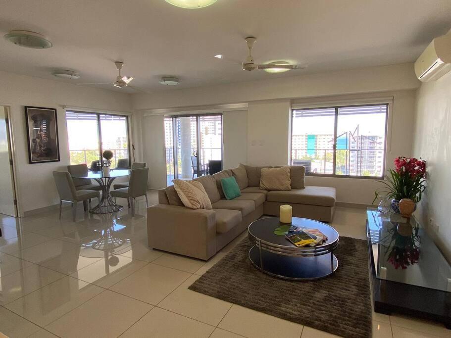 een woonkamer met een bank en een tafel bij Katara On Smith - 2 Bed 2 Bath CBD Appartment in Darwin