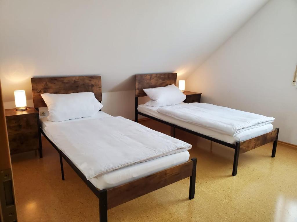 two beds with white sheets in a room at Ferienwohnung Fröse in Altenbeken