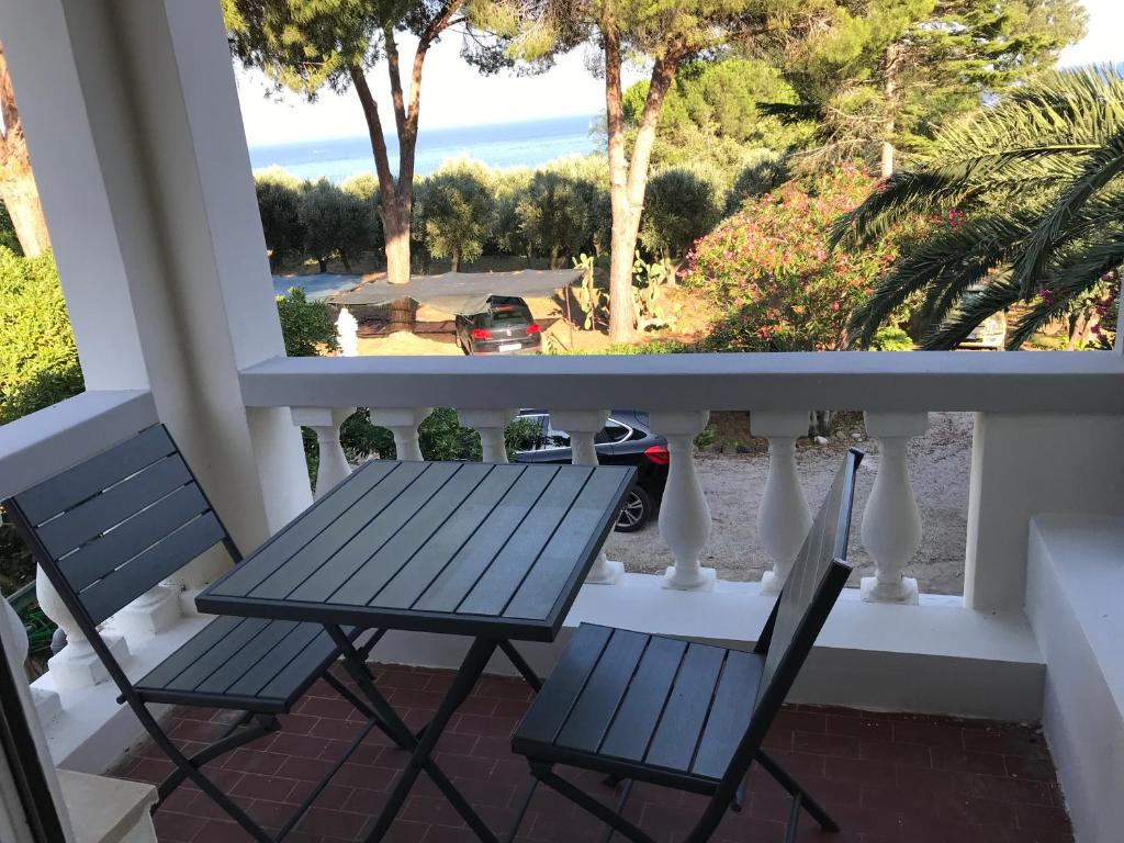 un tavolo e sedie su un balcone con vista sull'oceano di Isola d'Elba casa vacanze - Villa Portello - la casina bis - quarzo-pirite a Rio Marina