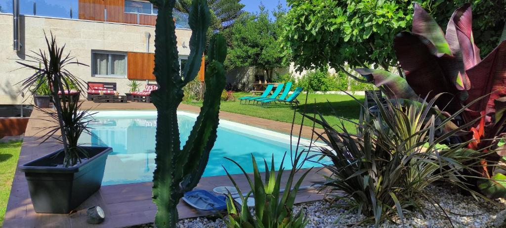 uma piscina com plantas num quintal em Casa playa La Solana en Nigran em Nigrán
