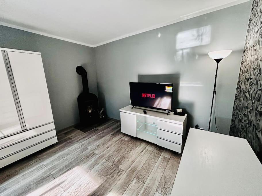 a living room with a flat screen tv and a guitar at Apartament Ksiazeca in Jelenia Góra