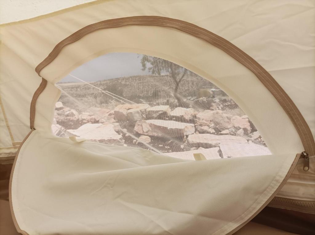 a view of a tent through a round window at Barrieh in Rammūn