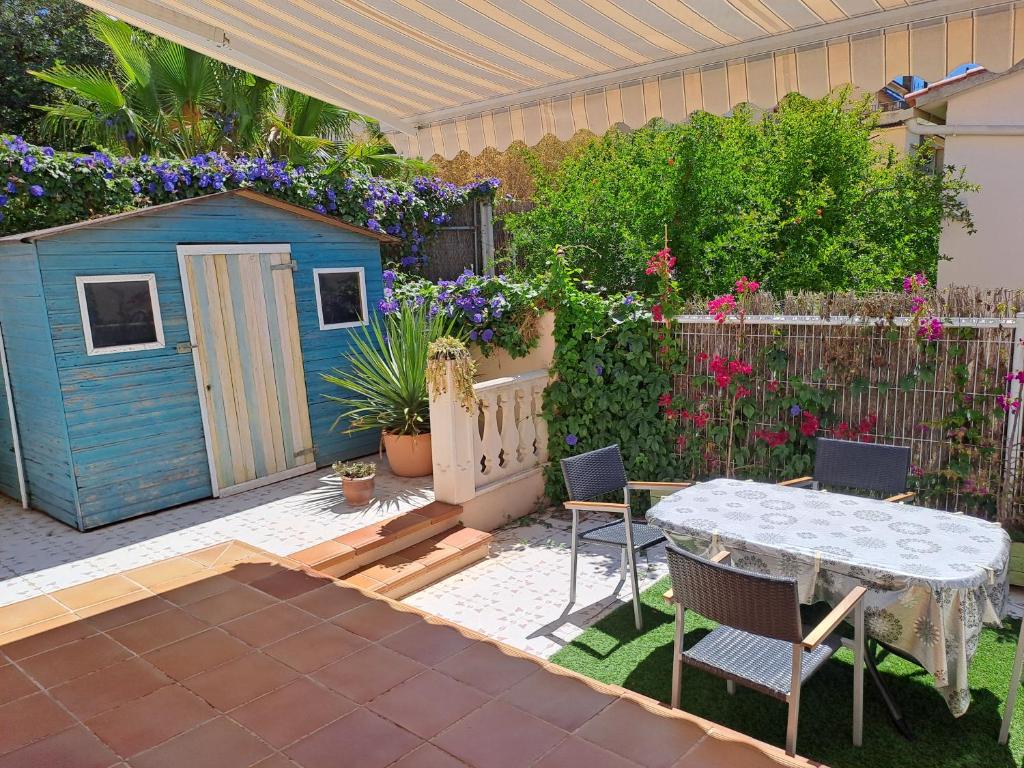 a backyard with a table and a blue shed at Torredembarra House in Torredembarra