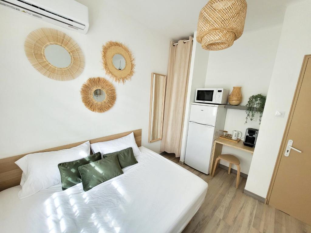 niewielka sypialnia z białym łóżkiem i kuchnią w obiekcie Chambre climatisée lit double dans villa - Proche Centre Tramway w Montpellier