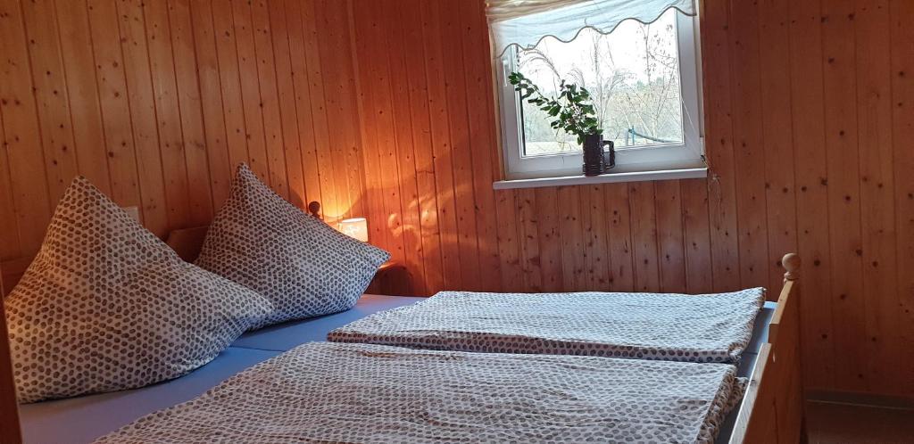 1 dormitorio con cama con almohadas y ventana en ferienhaus-am-scharmützelsee, en Wendisch Rietz