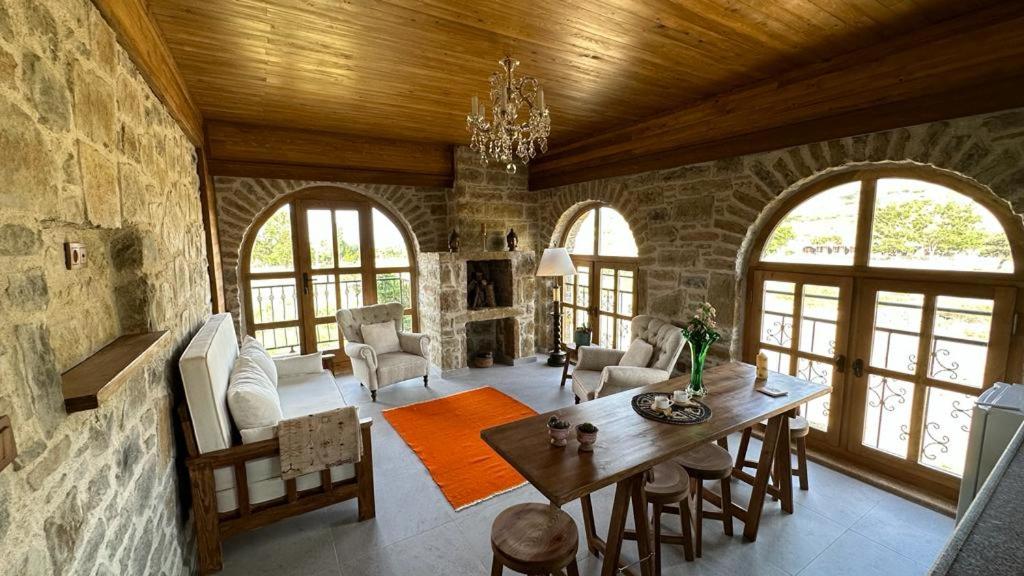 a living room with a wooden ceiling and a table and chairs at KİNZİ İMROZ in Gokceada Town