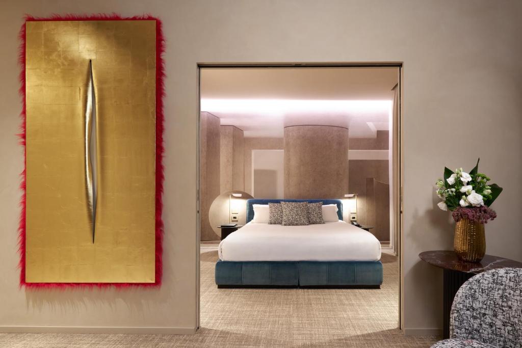 Borghese Contemporary Hotel في روما: غرفة نوم بسرير ومرآة كبيرة