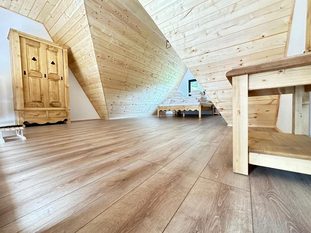 een zolderkamer met een houten plafond en houten vloeren bij A Frame Chalet By Superski in Cavnic