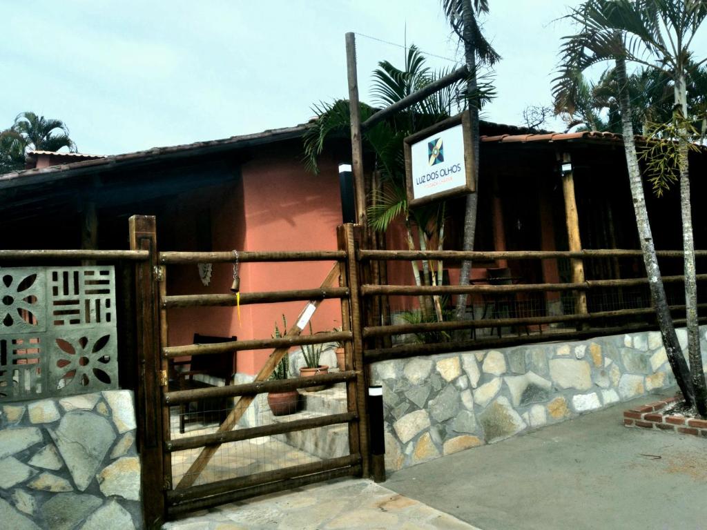 un portail devant une maison avec un panneau dans l'établissement Pousada Luz dos Olhos, à Alexânia