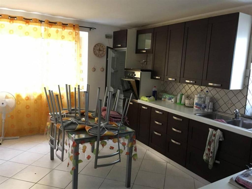 - une cuisine avec une table, des chaises et un évier dans l'établissement La Piccola Valle, à Vallefiorita