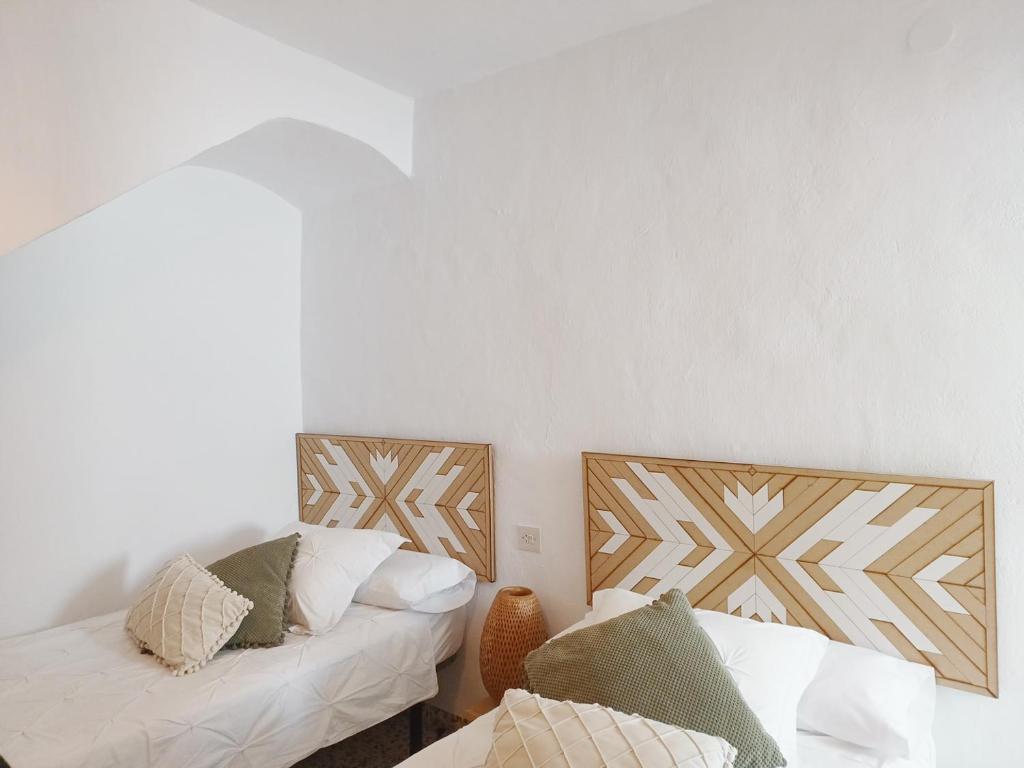 twee bedden in een kamer met witte muren bij Las Pizarrillas: tu hogar en este blanco pueblo in Frigiliana