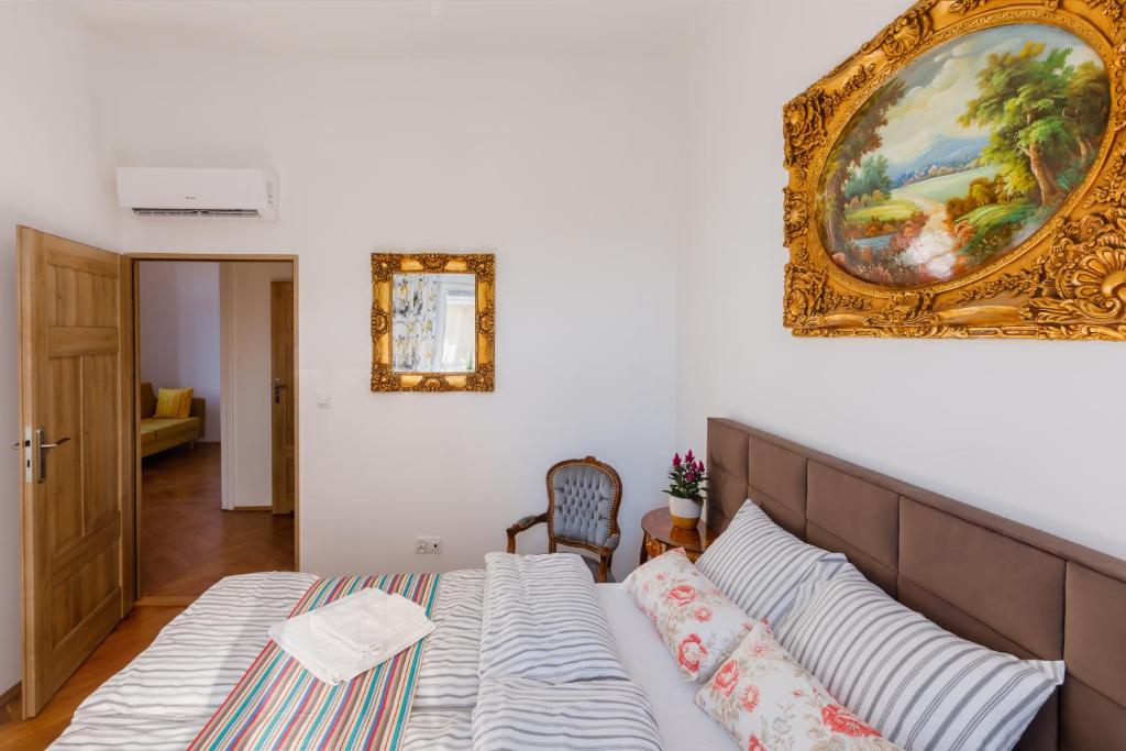 a bedroom with a bed and a painting on the wall at OK LUX Apartments in Krakow
