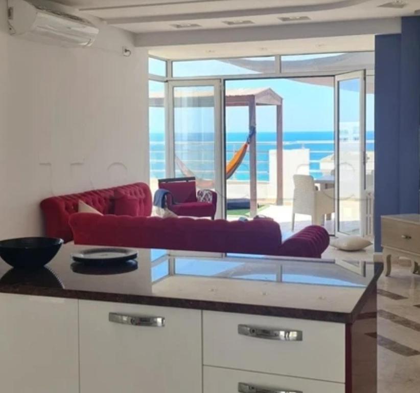 a living room with a red couch and a view of the ocean at Luxurious pent house in sousse in Sousse