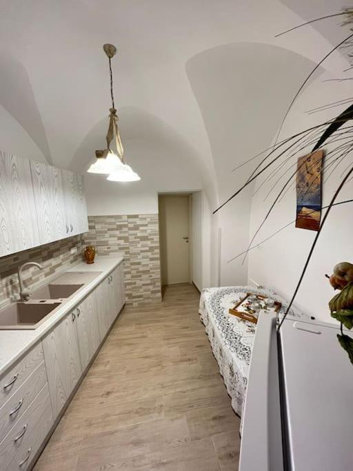 - une cuisine avec des placards blancs et un lit dans l'établissement Stelle secolari, à Corsano