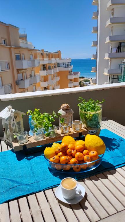 a plate of fruit on a table on a balcony at Cantinho do Sol - Sea view, Quiet, Cozy and Relaxing Flat in Armação de Pêra