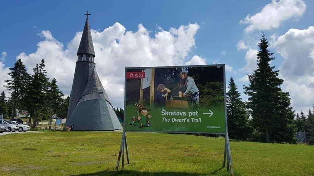 a sign in the middle of a field with a tower at Rogla - Chalet Mojca Pokrajculja in Zreče