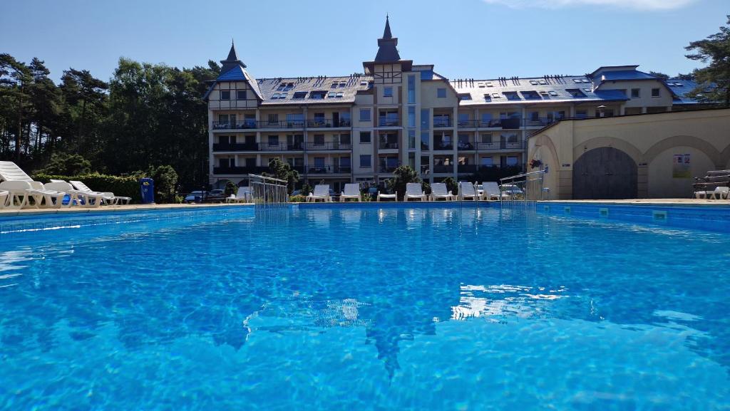 a large swimming pool in front of a hotel at Komfortowy Apartament w Blue Mare in Łukęcin