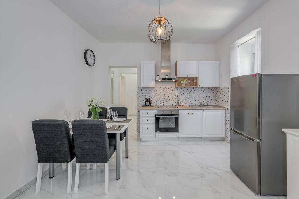 een keuken met een tafel met stoelen en een koelkast bij New place in Old town of Trogir, parking in Trogir
