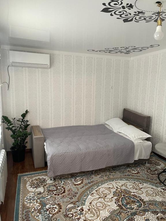 a bedroom with a bed and a rug at Paradise Turkistan in Türkistan