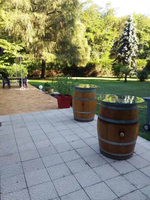 zwei Fässer sitzen auf einer Terrasse in einem Park in der Unterkunft Verdure tourangelle in Azay-sur-Cher