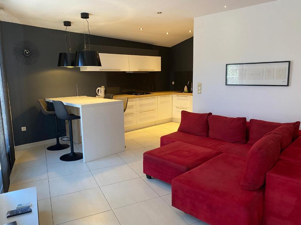 a living room with a red couch and a kitchen at Guest House Lorenta in Vodice