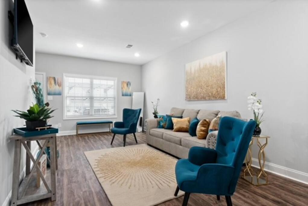 a living room with a couch and two blue chairs at Stay Happy in Clarksville